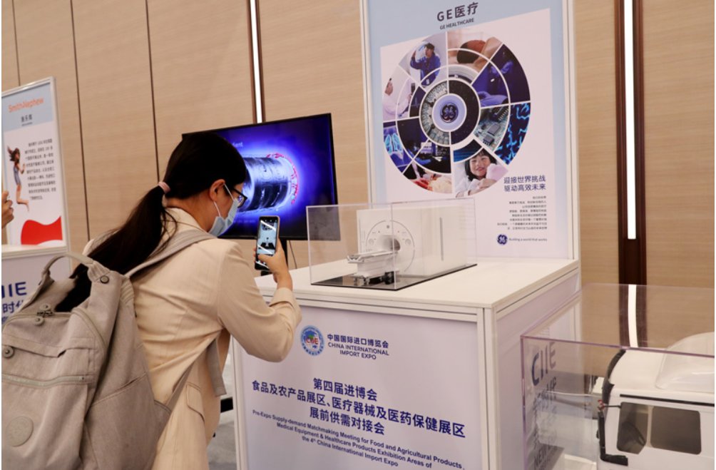 第四屆進博會食品及農(nóng)產(chǎn)品展區(qū)、醫(yī)療器械及醫(yī)藥保健展區(qū)展前供需對接會的參會嘉賓用手機拍攝參展企業(yè)的展品模型